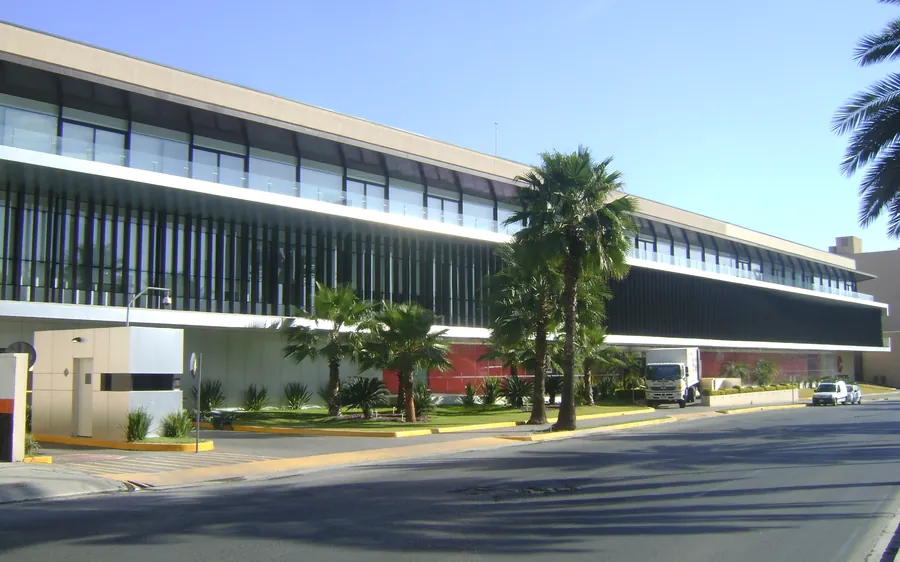 Fotografía del proyecto Arca Continental del portafolio LUCONSA: edificio corporativo de fachada horizontal con palmeras al frente