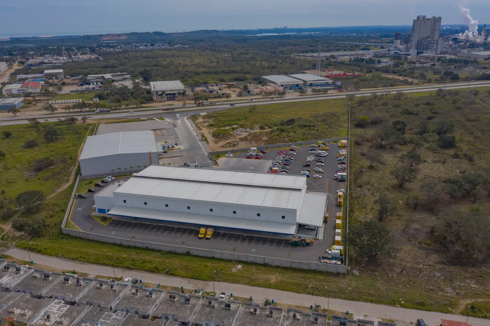 Fotografía del proyecto PepsiCo del portafolio LUCONSA: vista aérea de la nave con andenes y estacionamiento rodeada de vegetación