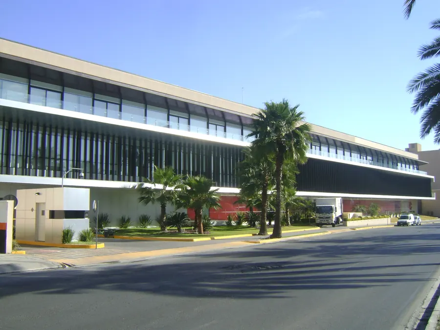 Fotografía del proyecto Arca Continental del portafolio LUCONSA: edificio corporativo de fachada horizontal con palmeras al frente