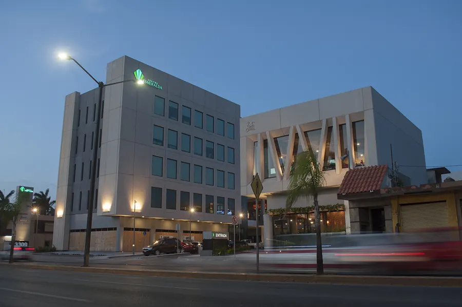 Fotografía del proyecto Centro Esmeralda del portafolio LUCONSA: edificio de oficinas y locales al anochecer