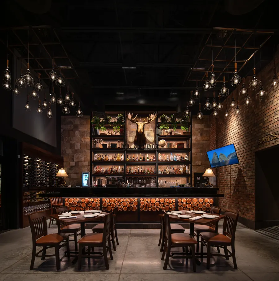Fotografía del proyecto El Asador Terraza del portafolio LUCONSA: salón con barra y muro de botellas