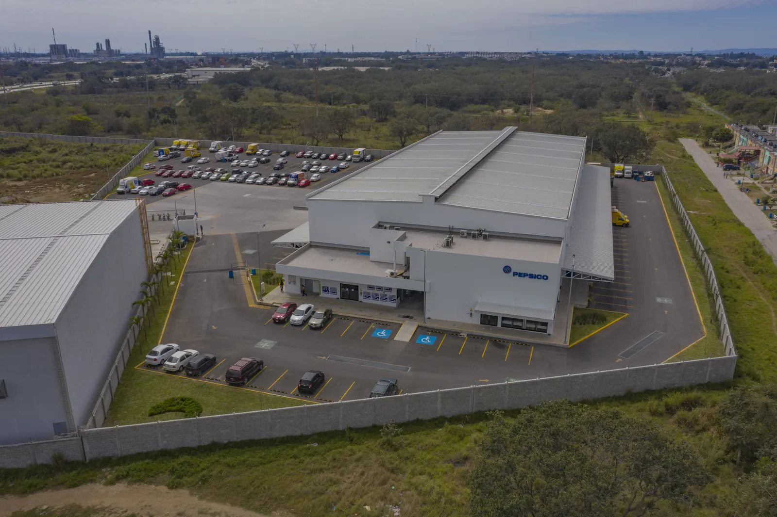 Fotografía del proyecto PepsiCo del portafolio LUCONSA: vista aérea del acceso principal y estacionamiento de la nave