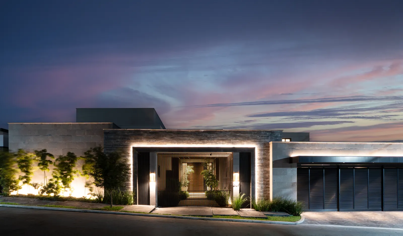 Fotografía del proyecto Residencias del portafolio LUCONSA: fachada de piedra con acceso iluminado al anochecer
