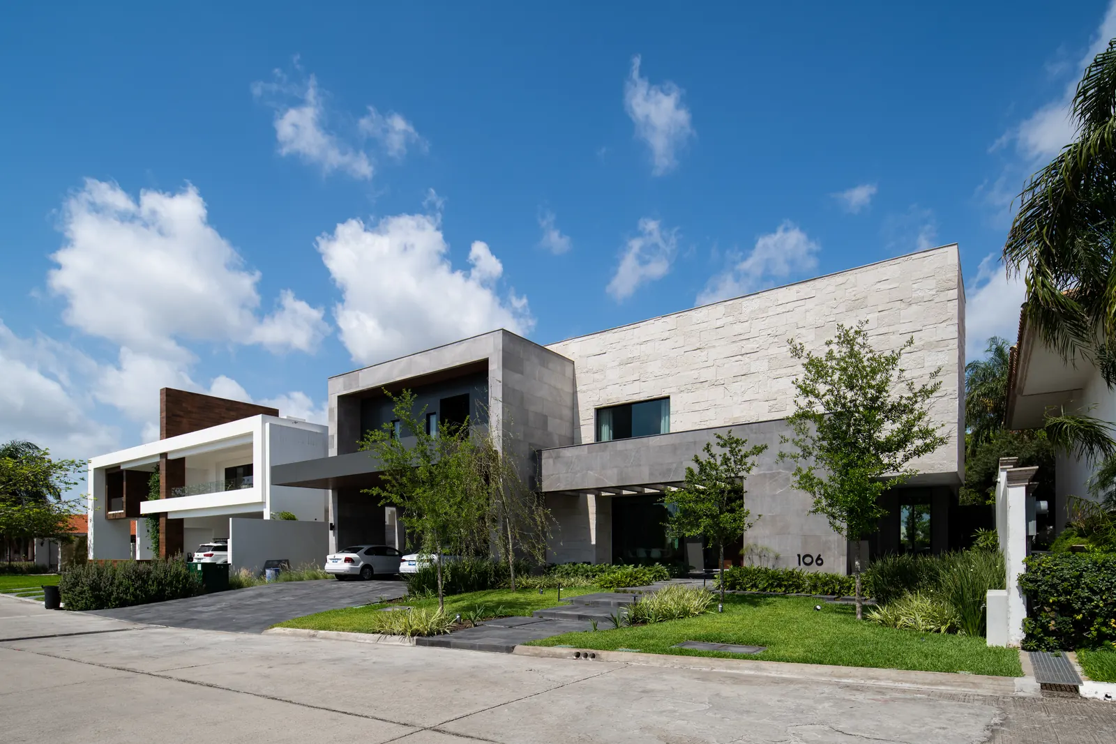 Fotografía del proyecto Residencias del portafolio LUCONSA: fachada de piedra y volúmenes con jardín frontal